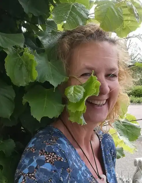 Nicole Trompetter die tussen haar planten staat.
